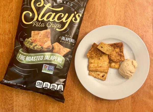 Stacy's Fire Roasted Jalape?o pita chips on a plate with hummus next to a bag of the pita chips