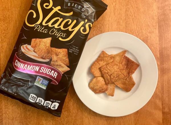 Stacy's Cinnamon Sugar pita chips on a plate next to a bag of the pita chips