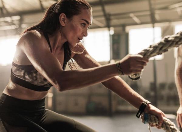 woman doing battle ropes, co<em></em>ncept of HIIT workouts for weight loss