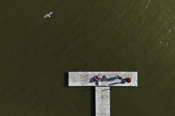 A family fishes in Lake Erie during an algal bloom, Wednesday, Sept. 4, 2024, in Toledo, Ohio. (AP Photo/Joshua A. Bickel)