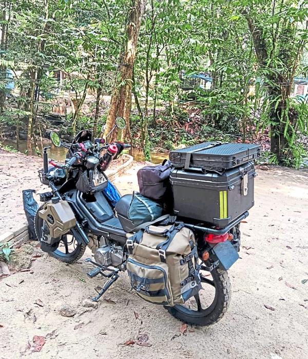 Chan’s 115cc bike being well-equipped with off-road tyres and his camping gear, including a three-litre jerry can of extra petrol.