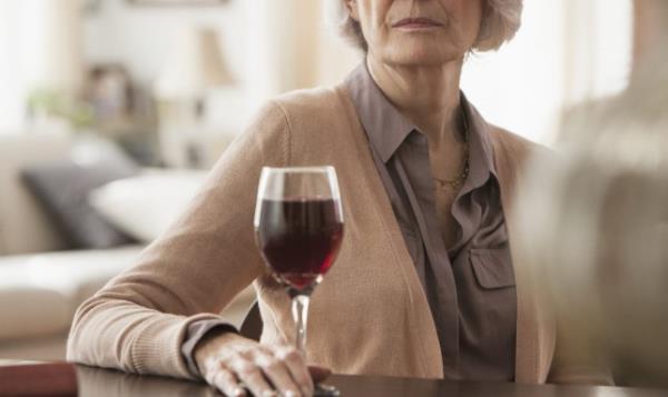 Senior Caucasian woman with glass of wine