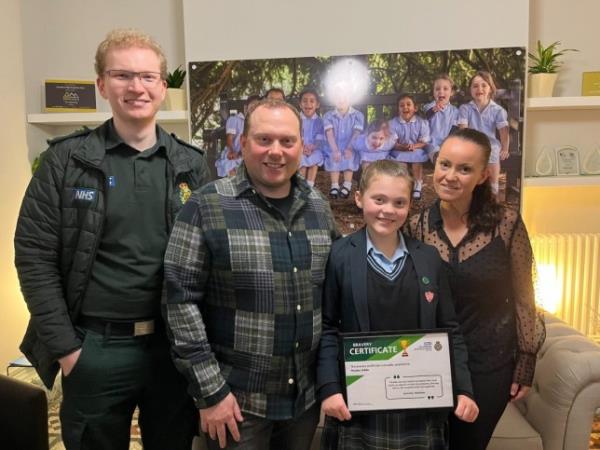 Phoebe Gibbs, 10, with her bravery certificate standing alo<em></em>ngside mum Leanne, dad Andy, and a member of East Midlands Ambulance Service 