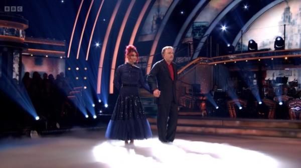 Chris McClausand and Dianne Buswell dancing together on Strictly Come Dancing. They are holding hands.