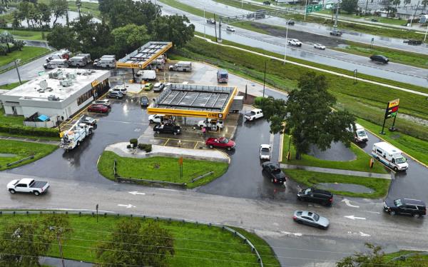 This drone picture shows people lining up in their cars for fuel at a gas station ahead of Hurricane Milton's expected landfall in Bradenton, Florida on October 9, 2024. - Milton regained power on October 8 to become a Category 5 storm with maximum sustained winds of 165 mph (270 kph) as it barrels towards the west-central coast of Florida and is forecast to make landfall late October 9, according to the Natio<em></em>nal Hurricane Center. (Photo by Miguel J. Rodriguez Carrillo / AFP)