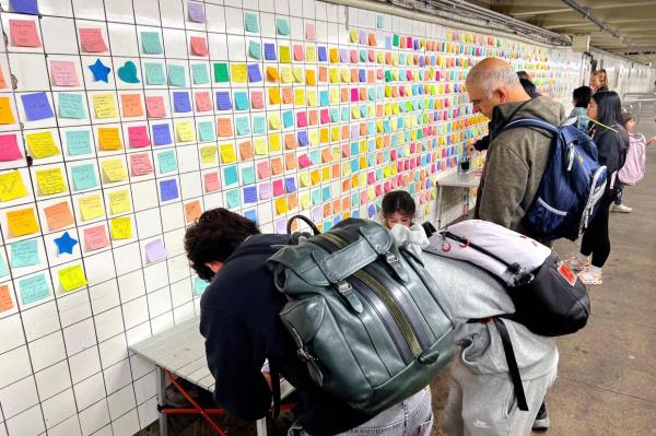 People leave post-it notes as they take part of the Subway Therapy project.