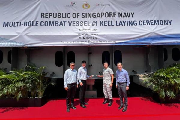 Mr Ong (second from left) and RADM Sean Wat, Chief of Navy (second from right) placing the coins on the keel during the 'coin ceremony'. This was witnessed by Mr Tan Leong Peng, President of ST Engineering's Marine division (first from left) and Mr Ng Chad-Son, Chief Executive, Defence Science and Technology Agency (DSTA) (first from right) (Republic of Singapore Navy)