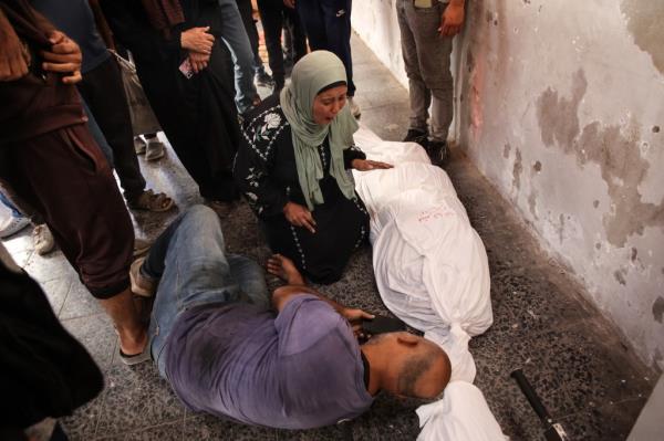 Relatives react over the shrouded body of a person killed in an Israeli strike that targeted areas in the northern Gaza Strip on Thursday.