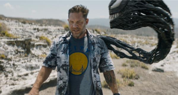 Tom Hardy walking in a field with a large black and white mo<em></em>nster in a scene from the film 'Venom: The Last Dance' released by Sony Pictures