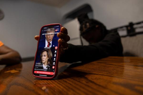 Julnise Telorge, an 18-year-old high school senior, shows a TikTok video of Republican presidential nominee and former U.S. President Do<em></em>nald Trump and Democratic presidential nominee and U.S. Vice President Kamala Harris during the last presidential debate at the home table in Charleroi, Pennsylvania, U.S., September 25, 2024. 