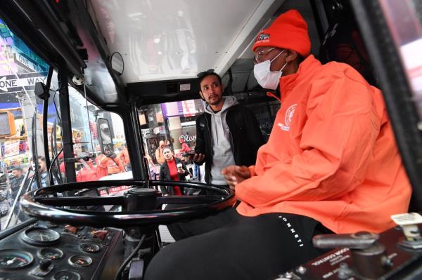 Bamise Jegede, owner of New York Ico<em></em>nic Cruises bus tours, wearing a mask and seated inside a bus