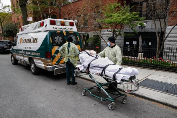 In this April 17, 2020, file photo, a patient is wheeled out of Cobble Hill Health Center by emergency medical workers in the Brooklyn borough of New York.