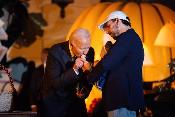 US President Joe Biden kisses a baby as he hosts a Halloween trick-or-treat event at the South Portico of the White House in Washington, DC, on October 30, 2024. 