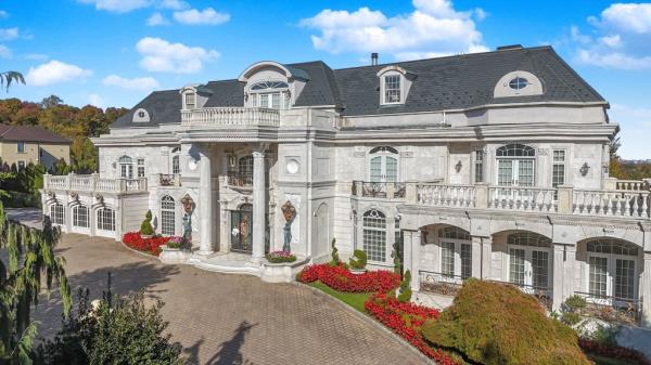 The stately exterior of the residence, which stands behind gates.
