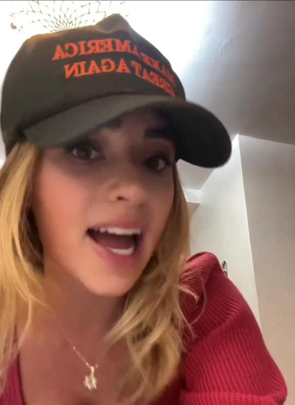A young woman in a MAGA hat wearing a Star of Da