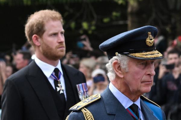 King Charles III and Prince Harry, Duke of Sussex, in military uniforms walking behind the coffin of Queen Elizabeth II during a procession in London
