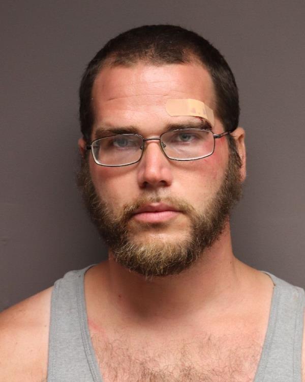 A mugshot of Robert Fisher. He has a bandage over his left brow and has bruising on his face.