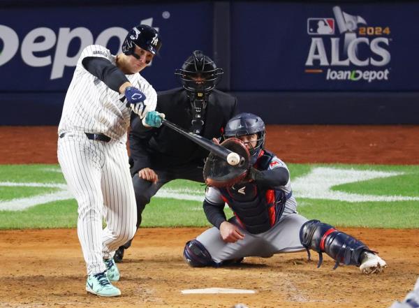 New York Yankees player Anthony Rizzo (48) hitting a double and enabling teammate Anthony Volpe (11) to score during an ALCS game against the Cleveland Guardians at Yankee Stadium.