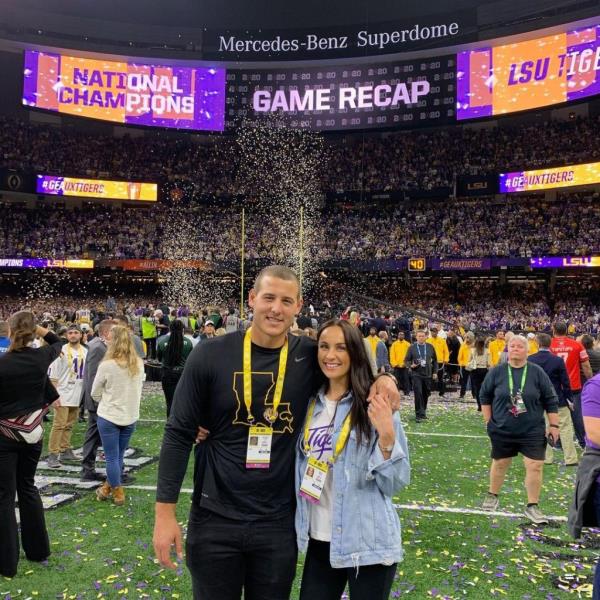 Anthony Rizzo and wife Emily Rizzo posing for a picture in a stadium