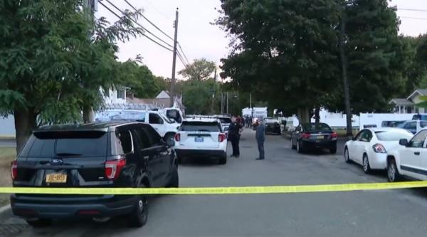 Police stand in the street during their investigation. 