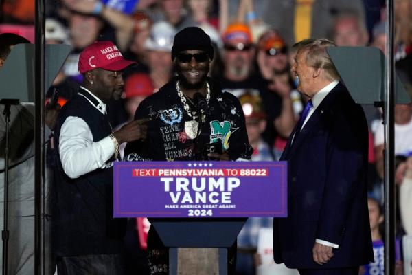 Republican presidential nominee former President Do<em></em>nald Trump listens to former Pittsburgh Steelers Anto<em></em>nio Brown, left, and, Le'Veon Bell, at a campaign rally, Saturday, Oct. 19, 2024