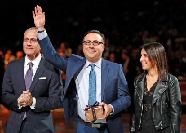 Brooklyn Nets CEO Brett Yormark, left, applauds veteran Nets broadcaster Ian Eagle, center, who acknowledges the crowd after accepting a gift from Yormark as the Nets celebrated Eagle's 25-year career
