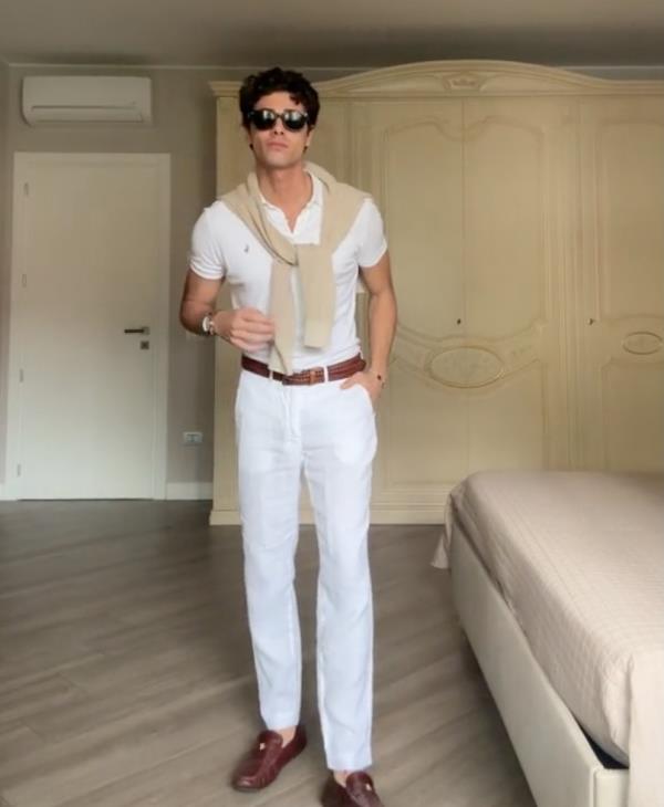 TikTokker posing in white clothes, resembling styles inspired by the Menendez brothers highlighted in a recent Netflix true crime series.