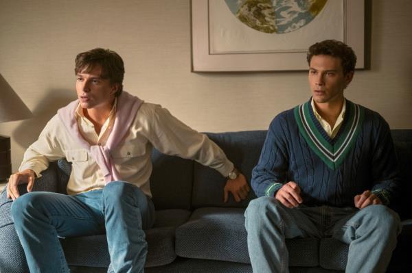 Actors Nicholas Chavez and Cooper Koch portraying Lyle and Erik Menendez in a scene from the Netflix series 'MONSTER', sitting on a couch