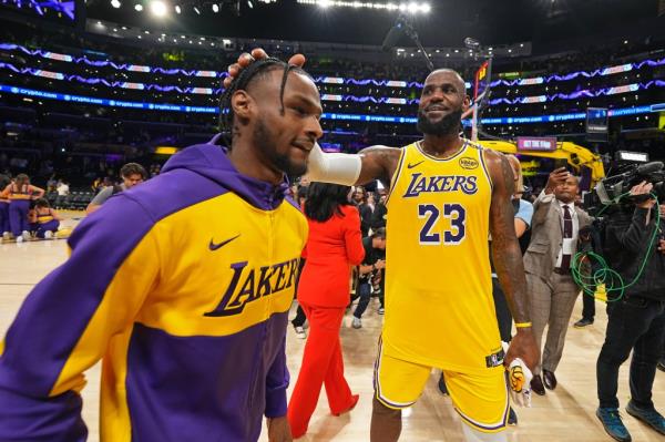 Bro<em></em>nny James #9 and LeBron James #23 of the Los Angeles Lakers high five after the game against the Minnesota Timberwolves on October 22, 2024 at Crypto.Com Arena in Los Angeles, California.