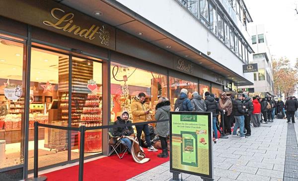 Customers lining up in front of a chocolate shop in Stuttgart. — AFP