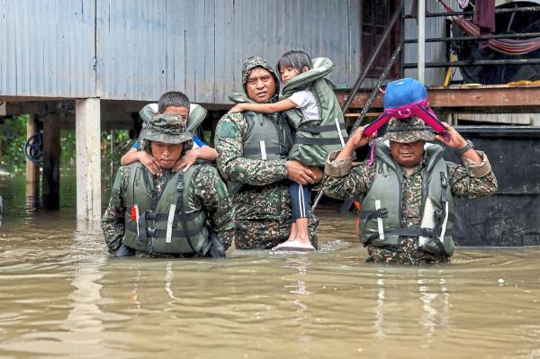 Easy does it: soldiers rescuing stranded children at Kg Tengkawang in Kuala berang, Terengganu. — bernama
