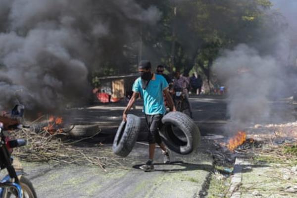 Tires are placed on a burning barricade in an attempt to deter gang members from entering a neighborhood in Port-au-Prince, Haiti, Tuesday, 19 November 2024.