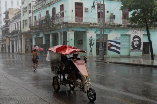 A woman i seen walking on the street as Hurricane Rafael passes by Havana, Cuba.
