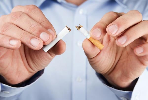 A man breaks a cigarette in half