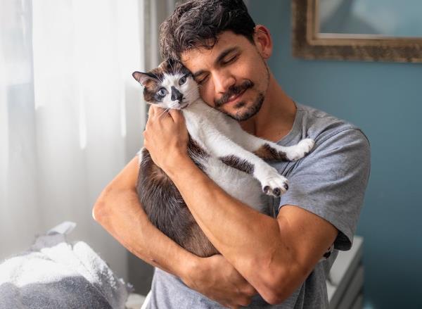 A man touching heads affectio<em></em>nately with his cat