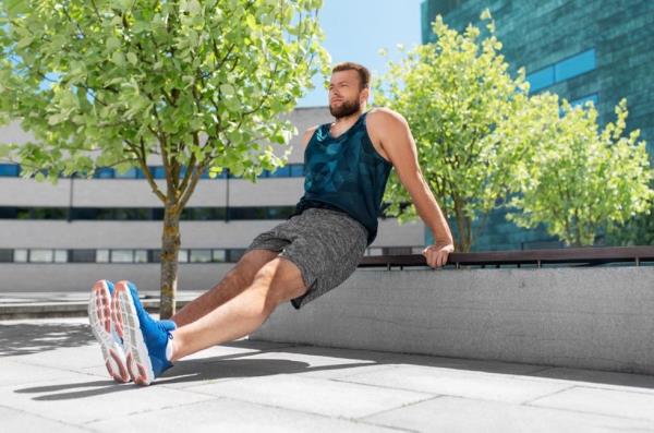 man doing tricep dips on a bench