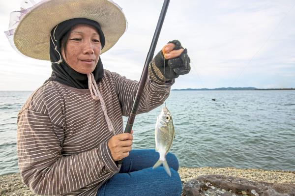 An angler showing how she uses a simple basic rod and line method to catch fish at the beach.