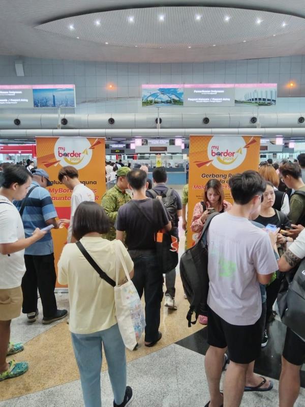 Perso<em></em>nnel statio<em></em>ned at the bus hall to advise people to register and use MyBorderPass application at the Bangunan Sultan Iskandar Customs, Immigration and Quarantine Complex (BSI) in Johor Baru.
