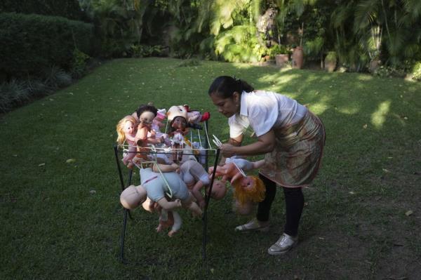 Irelis Baldirio hangs laundered used dolls to dry at the non-profit foundation Hospital de los Peluches, or Hospital of Stuffed Animals.