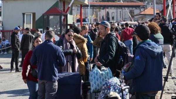 Foreign natio<em></em>nals arriving from Syria stand at the Lebanese Masnaa border crossing, Dec. 9, 2024. Turkey's foreign and defense ministries are coordinating evacuations of third-country natio<em></em>nals from Syria with logistical support of Turkish ground forces.