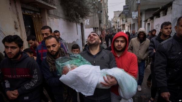 FILE - Mohammad Shouman carries the body of his daughter, Masa, who was killed in an Israeli bombardment of the Gaza Strip, during her funeral in Rafah, southern Gaza, Jan. 17, 2024. 