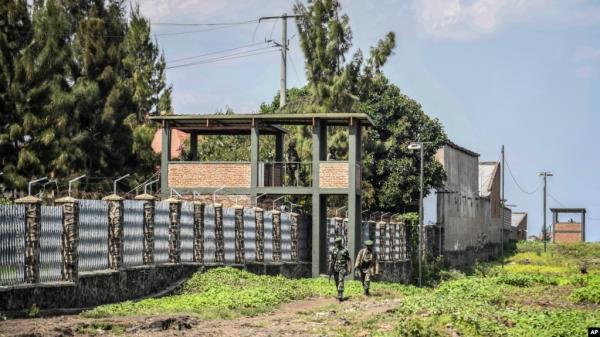 FILE - Rwandan security forces look out from their sentry box as Co<em></em>ngolese soldiers patrol on foot on their side of the border crossing with Rwanda in Goma, Congo, on June 17, 2022.