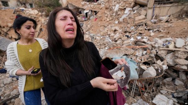 Zeina Rida Jawhari, reacts after recovering a photo of her father from the rubble of her destroyed house in Baalbek, Nov. 28, 2024. 