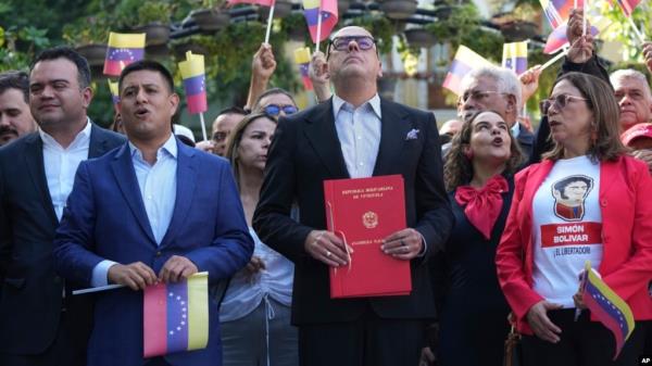 Natio<em></em>nal Assembly President Jorge Rodriguez, center, holds a bill that codifies eco<em></em>nomic sanctions as a crime against humanity and allows prosecution of anyone who expresses support for the measures, in Caracas, Venezuela, Nov. 28, 2024.