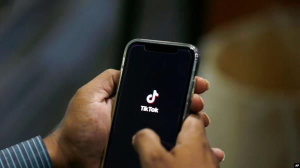 FILE - A man opens social media app TikTok on his cellphone, in Islamabad, Pakistan, July 21, 2020.
