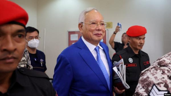 FILE - Former Malaysian Prime Minister Najib Razak escorted by prison officers as the jailed politician left the court after court proceedings in Kuala Lumpur, Malaysia January 19, 2024.