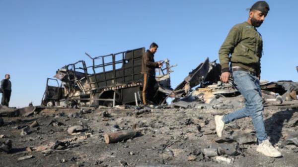 People gather around the damage by a burnt-out truck near Qamishli Internatio<em></em>nal Airport, after regio<em></em>nal security sources and officers within the now-fallen Syrian army said that Israeli airstrikes co<em></em>ntinued against military installations and airba<em></em>ses overnight across Syria, December 10, 2024. REUTERS/Orhan Qereman 