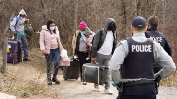 Asylum seekers cross into Canada from the US border near a checkpoint on Roxham Road near Hemmingford, Quebec, Canada April 24, 2022. Picture taken April 24, 2022. Photo: REUTERS/Christinne Muschi/File Photo