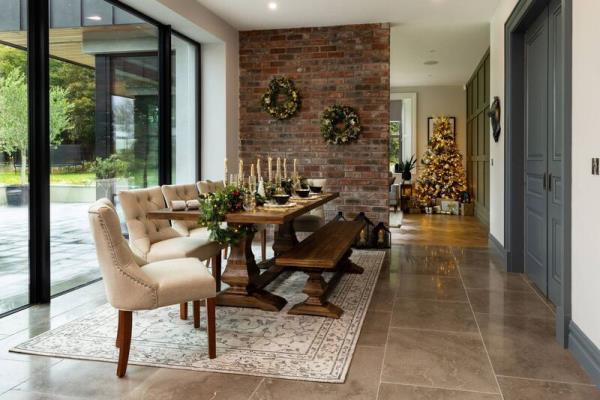 Using candles of different heights and weaving a garland along the centre of the dining table creates a decorative effect that doesn’t block the view across the table. Picture: EZ Living Interiors