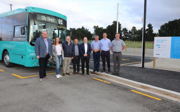 People standing in front of a bus which says city direct 91 on it.